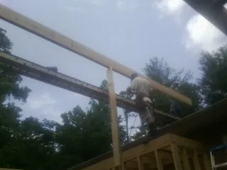Carpenter setting a ridge beam over a new addition frame — Ice Dam Removal by Roofing Brothers in Ranchita