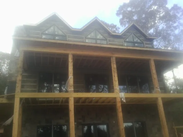 Dormers and porch framing on a large log home under construction — Roof Coating work by our crew in Ranchita